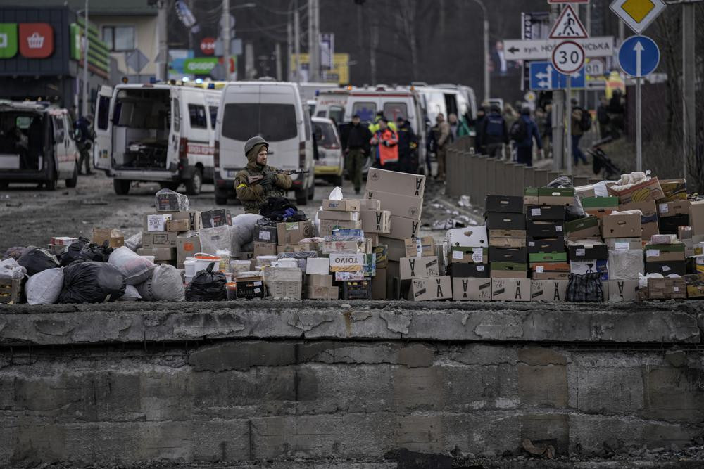 Một binh sĩ Ukraine đứng cung cấp thực phẩm ở Irpin, ngoại ô thủ đô Kiev, Ukraine. Ảnh: AP.