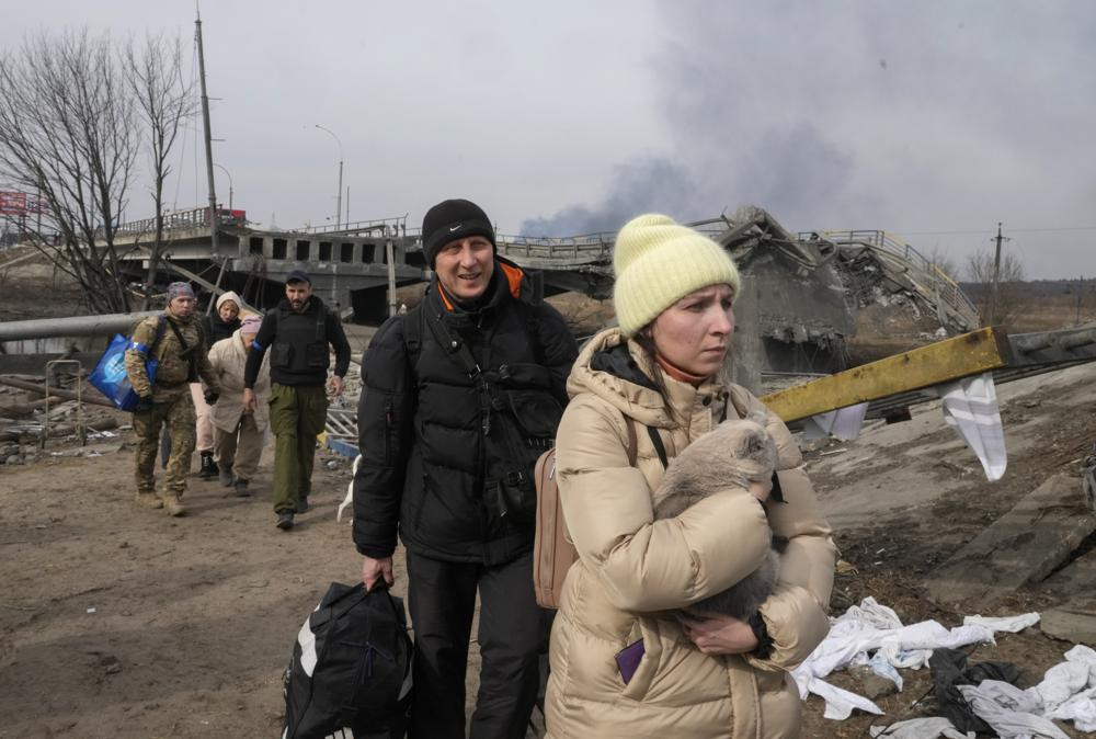 Người dân sơ tán trên con đường hướng tới thủ đô Kiev, ở thị trấn Irpin. Ảnh: AP.