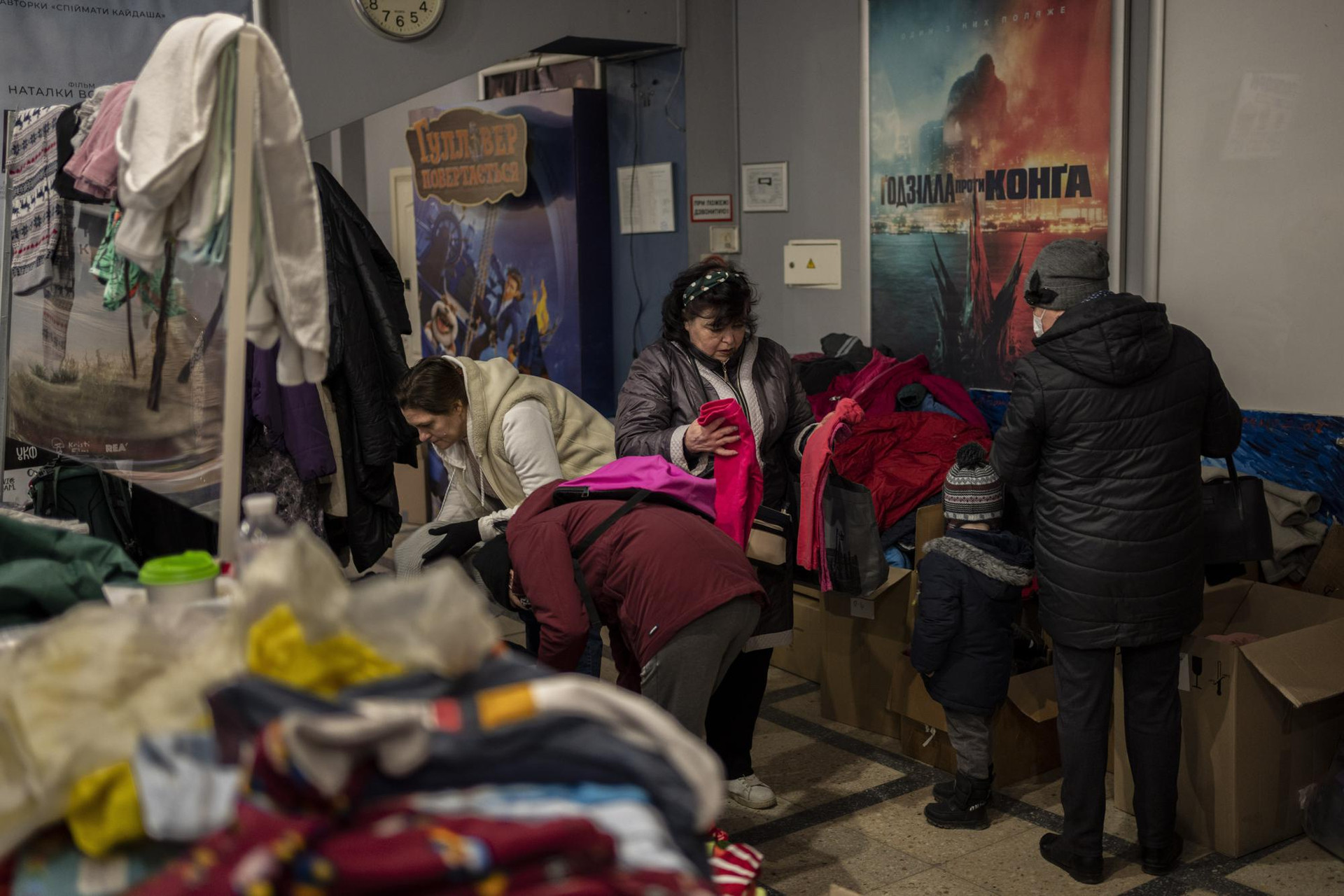 Người dân Ukraine chọn quần áo bên trong một trung tâm viện trợ tại rạp chiếu phim ở Lviv, miền tây Ukraine. Ảnh: AP.