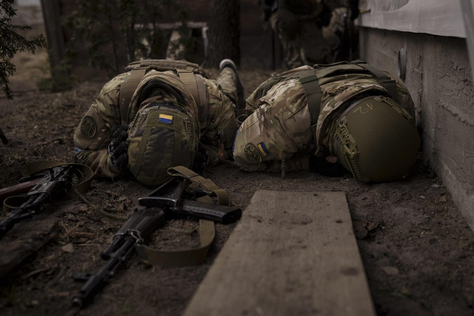 Binh sĩ Ukraine tránh đạn ở thị trấn Irpin, ngoại ô thủ đô Kiev. Ảnh: AP.
