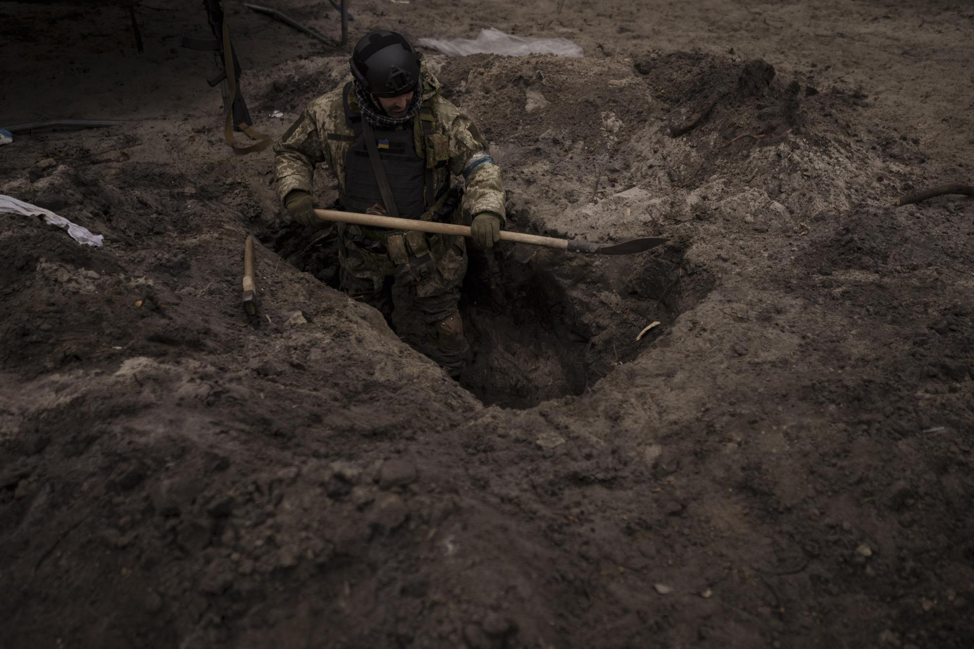 Một quân nhân Ukraine đào hố quân sự ở Irpin, ngoại ô thủ đô Kiev. Ảnh: AP.