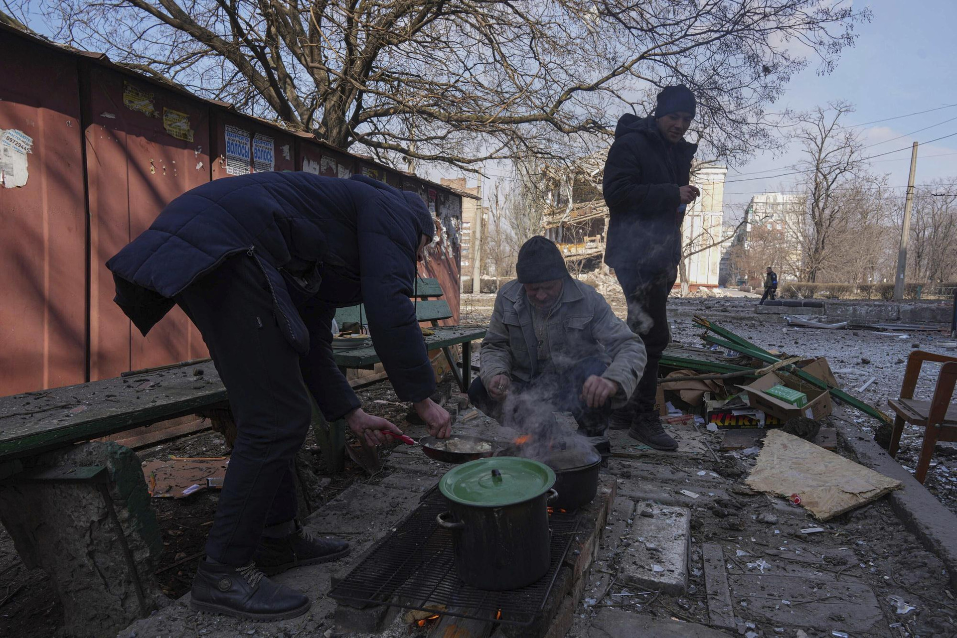 Những người đàn ông nấu ăn trên một con phố ở Mariupol, Ukraine. Ảnh: AP.