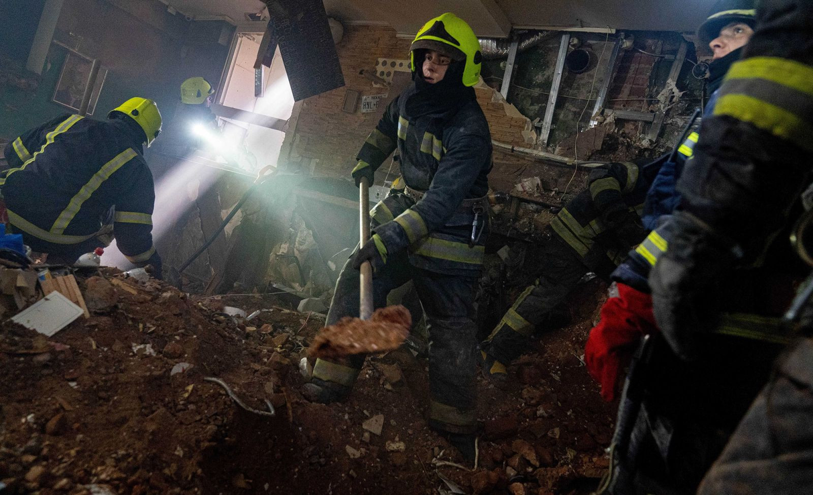 Các nhân viên cứu hộ tìm kiếm những người sống sót sau một đám cháy ở Kharkiv, Ukraine. Ảnh: CNN.