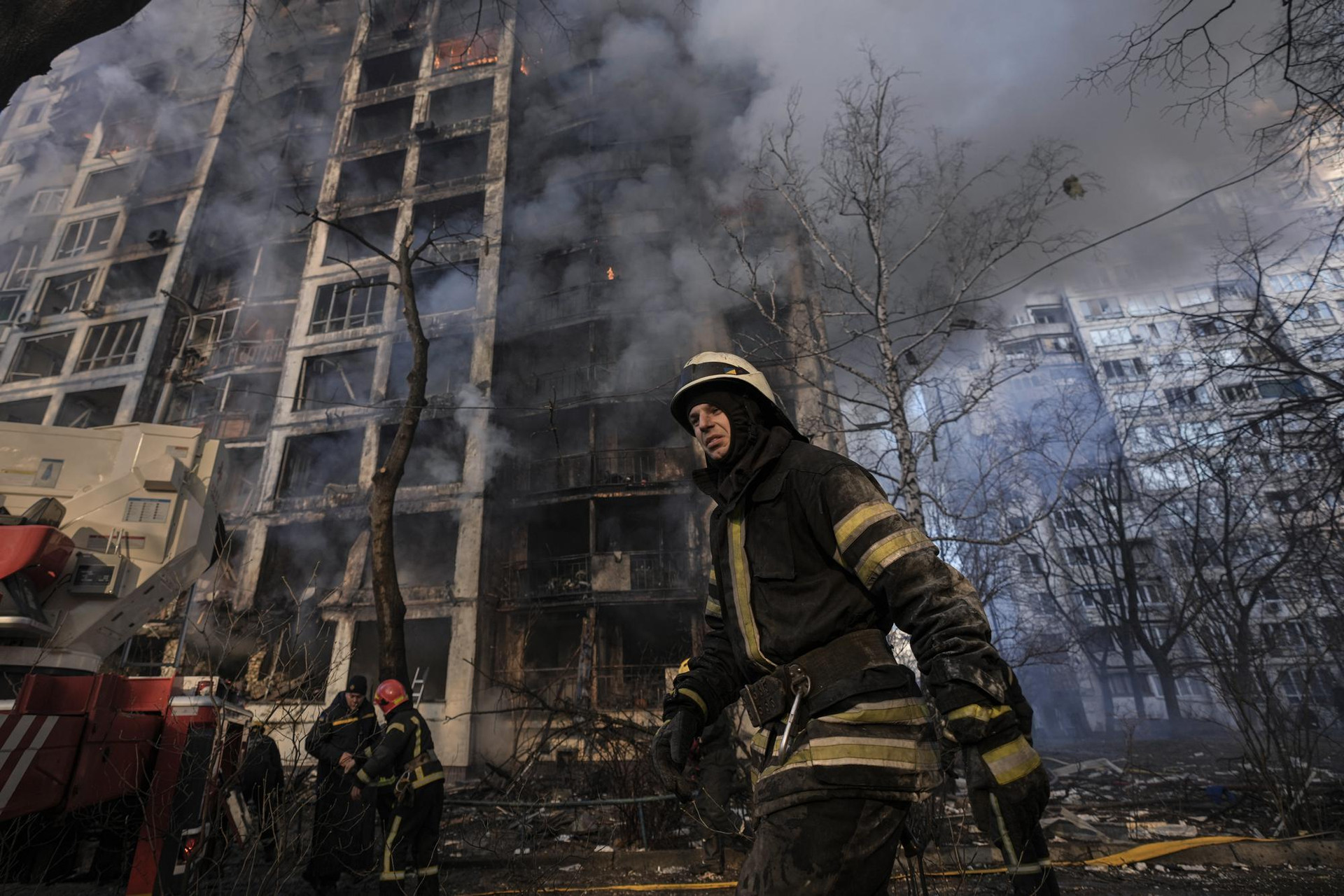 Những người lính cứu hỏa bên ngoài một tòa nhà bị phá hủy ở Kiev, Ukraine. Ảnh: AP.