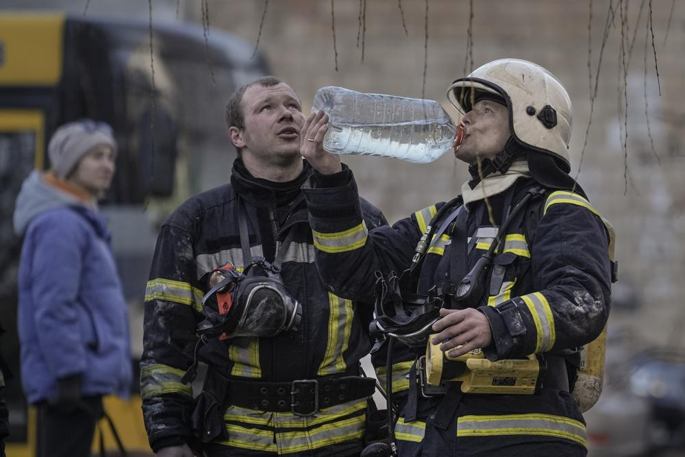 Những người lính cứu hỏa nỗ lực dập tắt ngọn lửa trong một tòa nhà bốc cháy ở Kiev, Ukraine. Ảnh: AP.