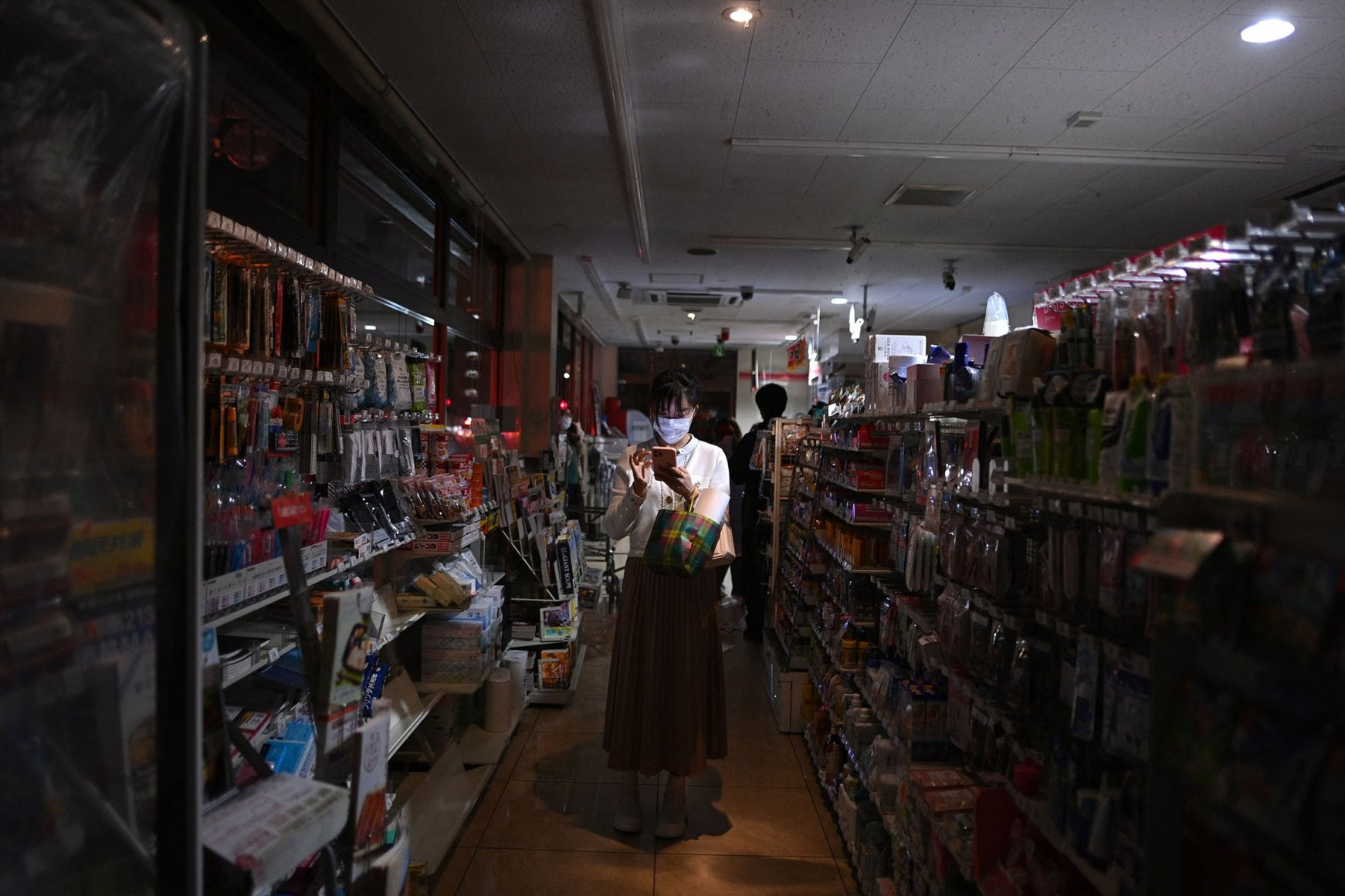 Người dân mua thực phẩm trong một cửa hàng bị mất điện sau động đất ở quận Koto, Nhật Bản. Ảnh: NY Post.