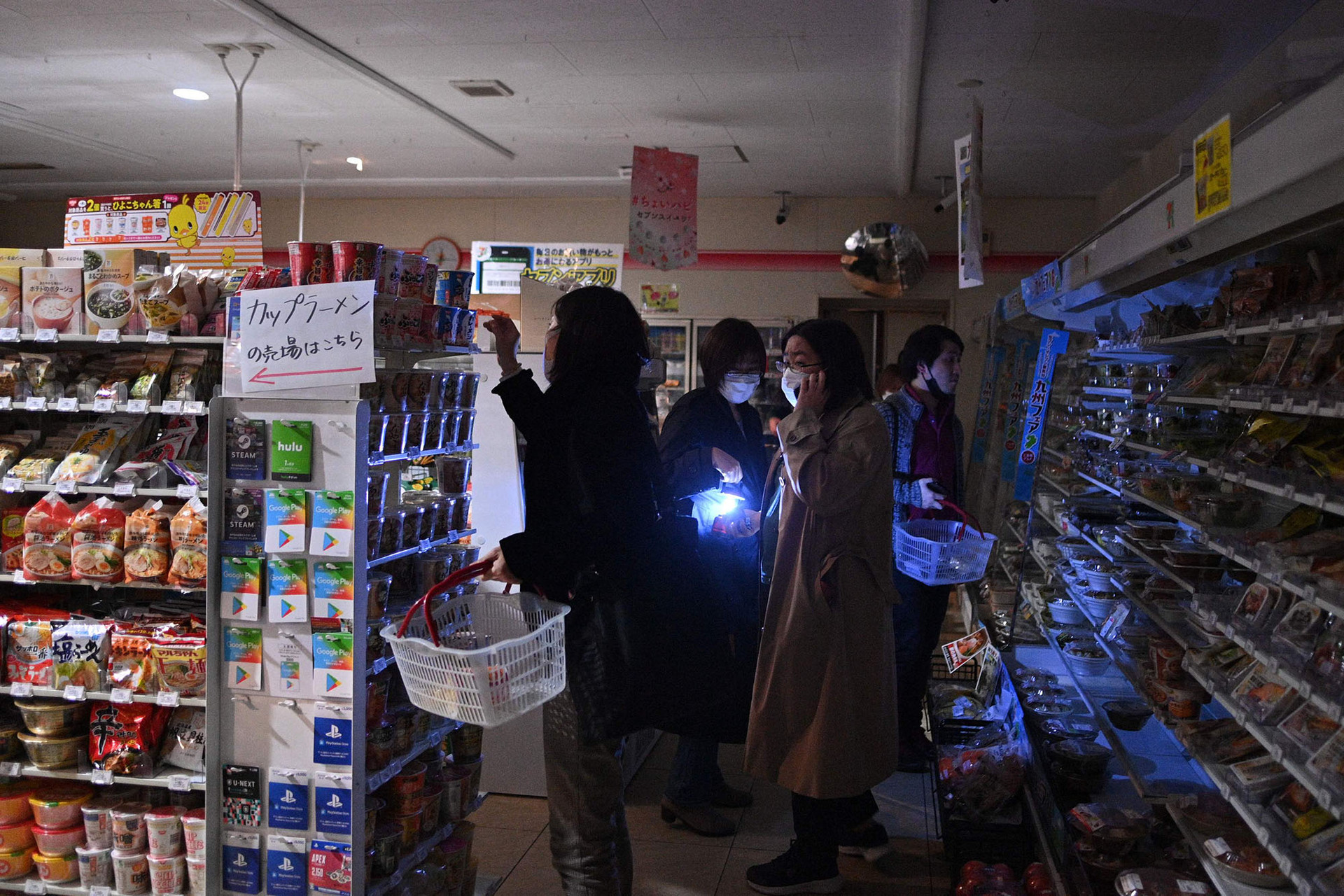 Người dân mua thực phẩm trong một cửa hàng bị mất điện sau động đất ở quận Koto, Nhật Bản. Ảnh: NY Post.