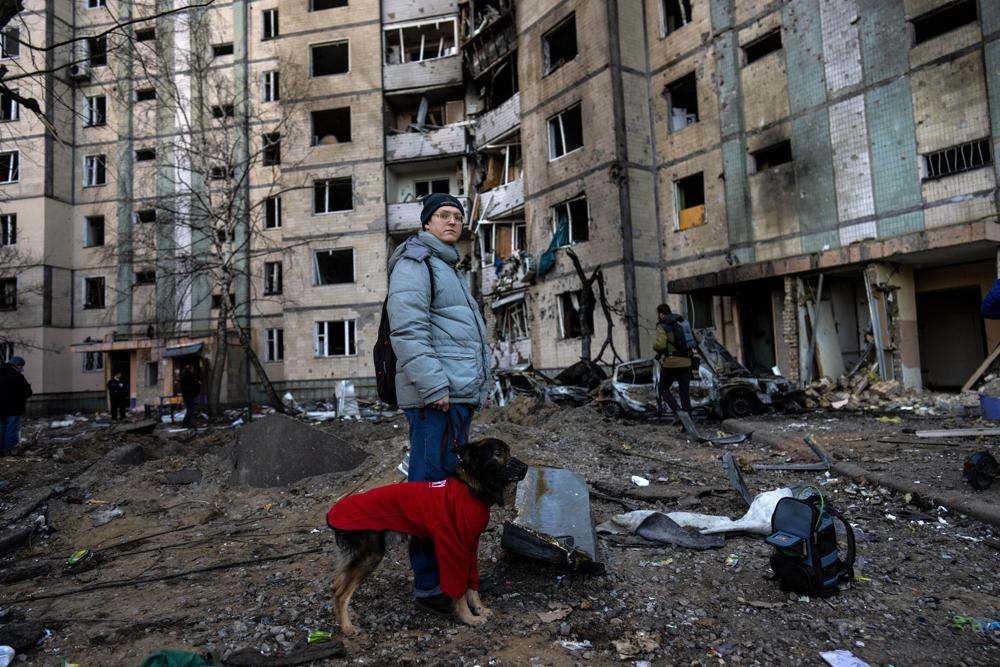 Người dân đứng cạnh tòa nhà bị phá hủy ở khu phố Satoya, thủ đô Kiev, Ukraine. Ảnh: AP.