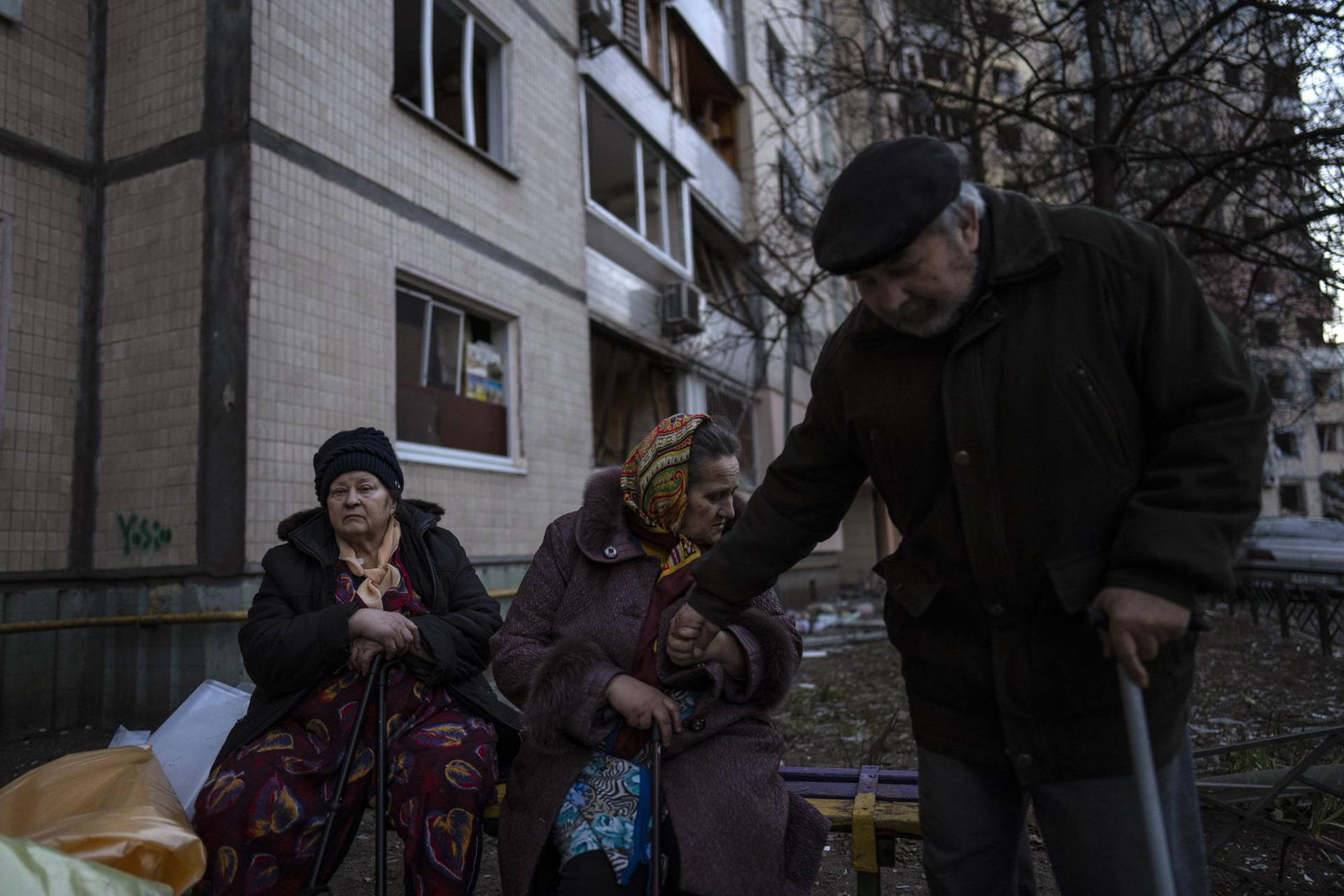 Mọi người tụ tập bên ngoài các tòa nhà bị phá hủy ở khu phố Satoya, thủ đô Kiev, Ukraine. Ảnh: AP.