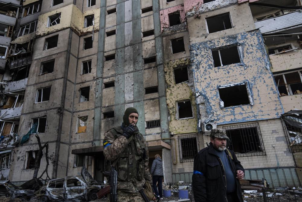 Binh sĩ Ukraine cạnh một tòa nhà bị phá hủy ở khu phố Satoya, thủ đô Kiev, Ukraine. Ảnh: AP.