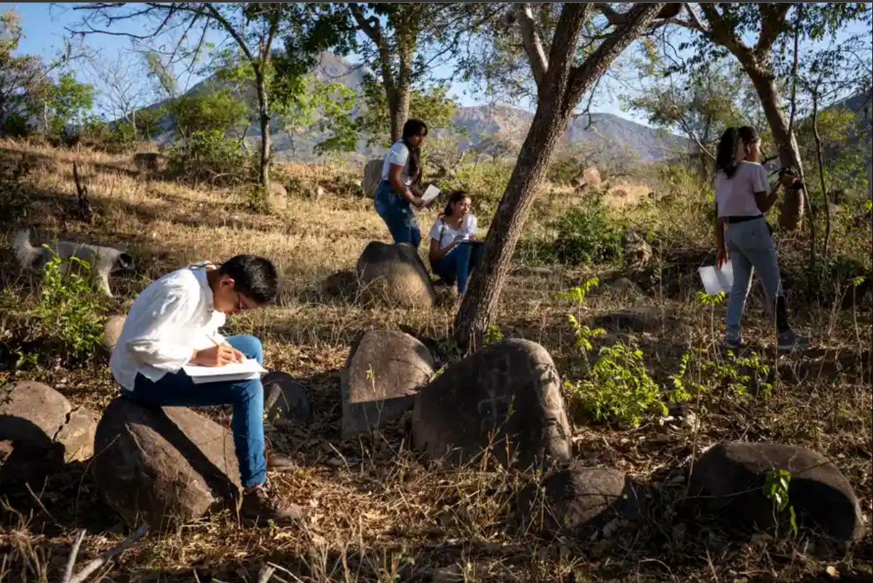 Những đứa trẻ ngồi khắc đá gần thị trấn Atánquez. Ảnh: The Guardian.