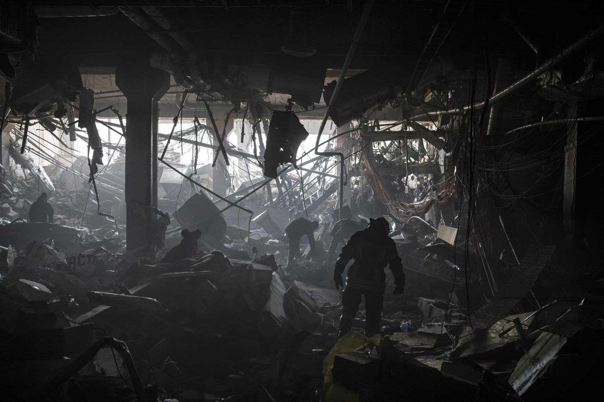 Các nhân viên cứu hỏa Ukraine tìm kiếm những người mất tích dưới đống đổ nát trong một trung tâm mua sắm tại thủ đô Kiev, Ukraine. Ảnh: AP.