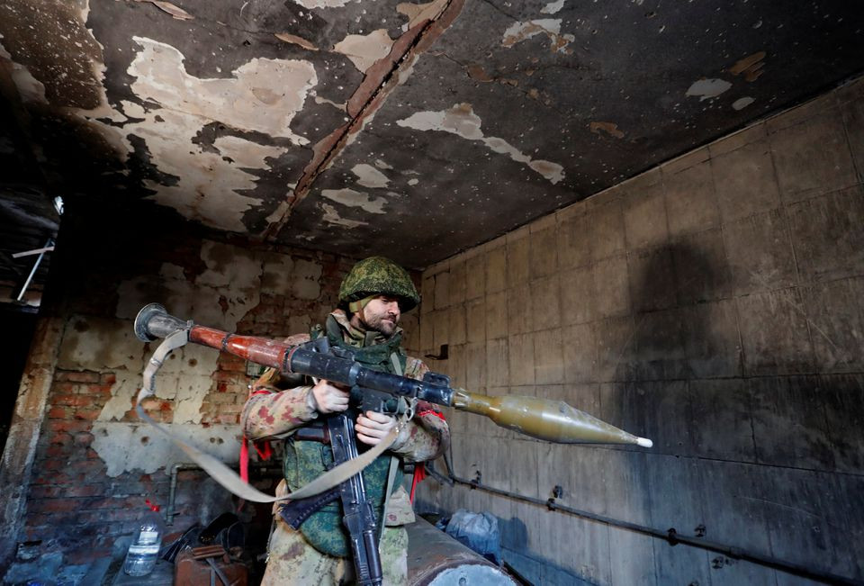 Quân nhân kiểm tra vũ khí bên trong một tòa nhà trước đây là vị trí chiến đấu của quân đội Ukraine tại thị trấn Marinka, thuộc Vùng Donetsk. Ảnh: Reuters.
