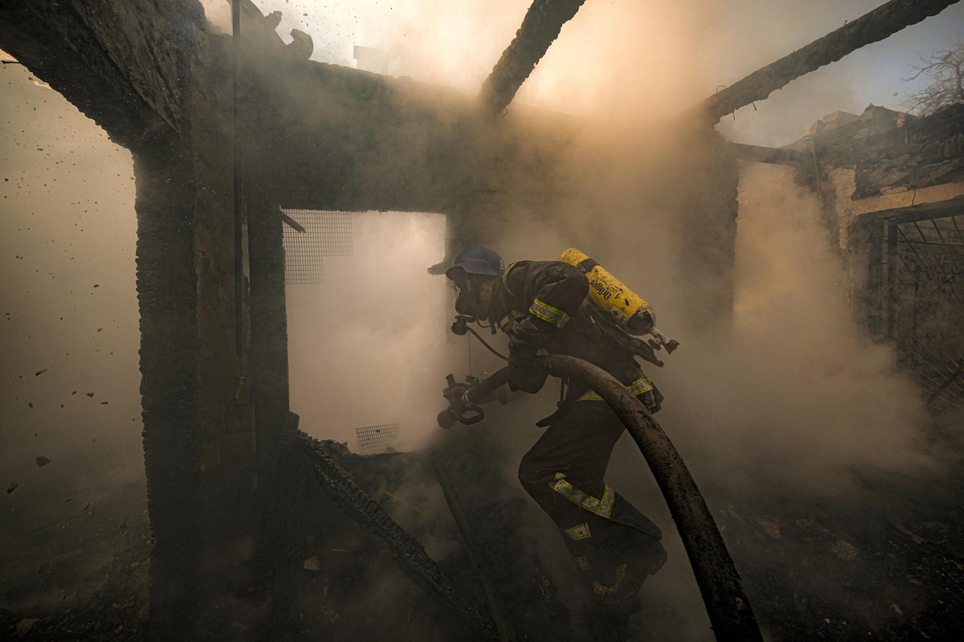 Một lính cứu hỏa Ukraine cố gắng dập tắt đám cháy bên trong một ngôi nhà bị phá hủy ở thủ đô Kiev, Ukraine. Ảnh: AP.