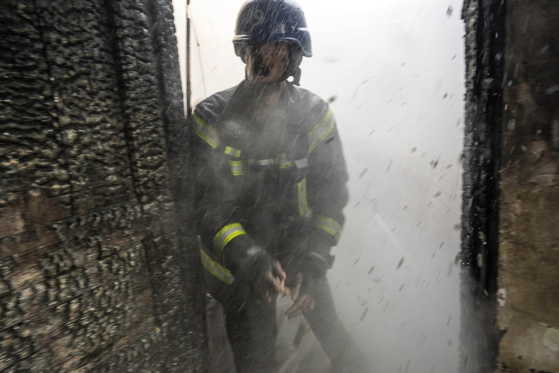 Lính cứu hỏa cố gắng dập tắt ngọn lửa bên trong một ngôi nhà bị phá hủy ở thủ đô Kiev, Ukraine. Ảnh: AP.