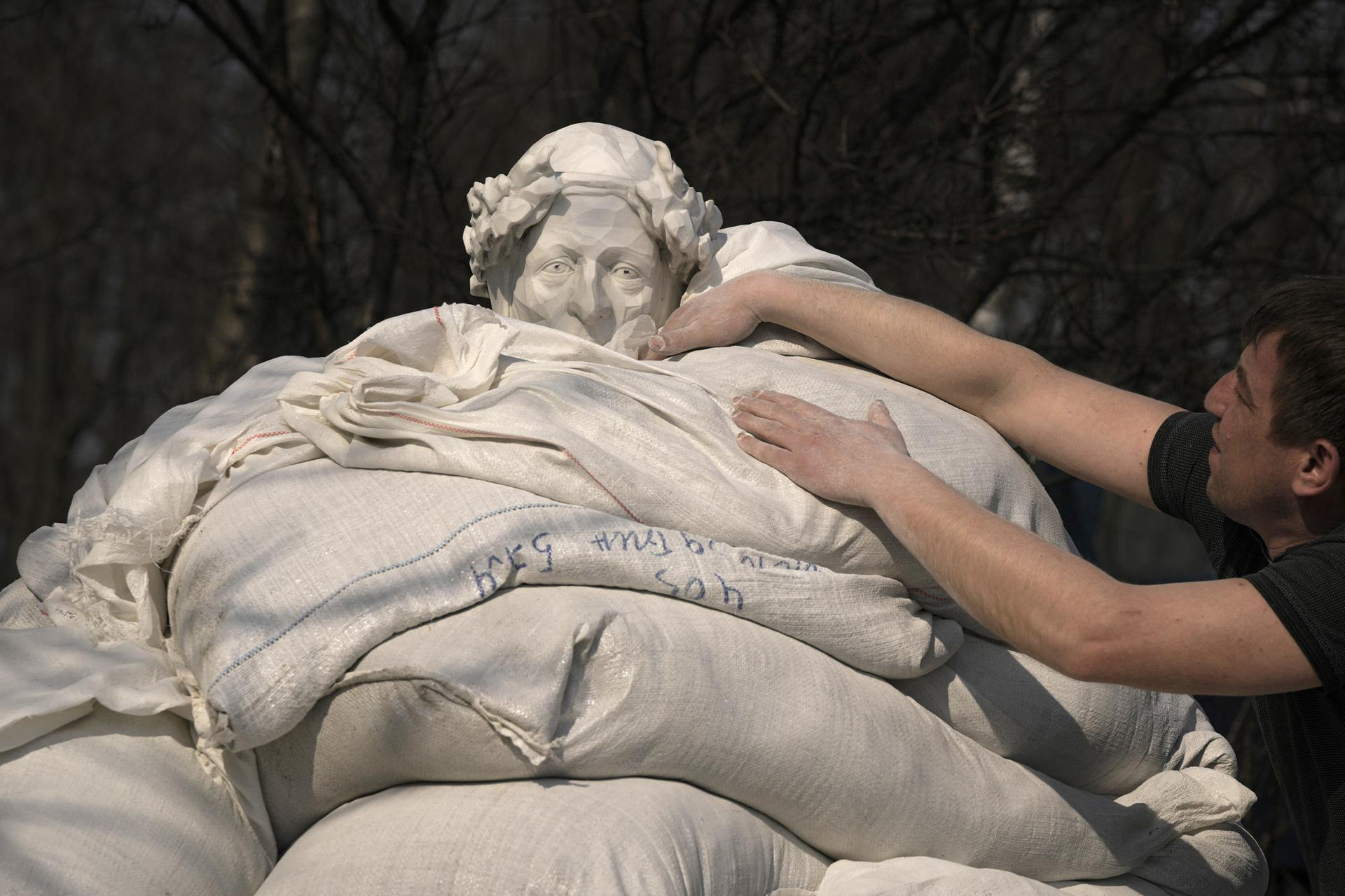 Công nhân thành phố bảo vệ bức tượng của nhà thơ và nhà triết học người Italy Dante Alighieri bằng bao cát ở thủ đô Kiev, Ukraine. Ảnh: AP.