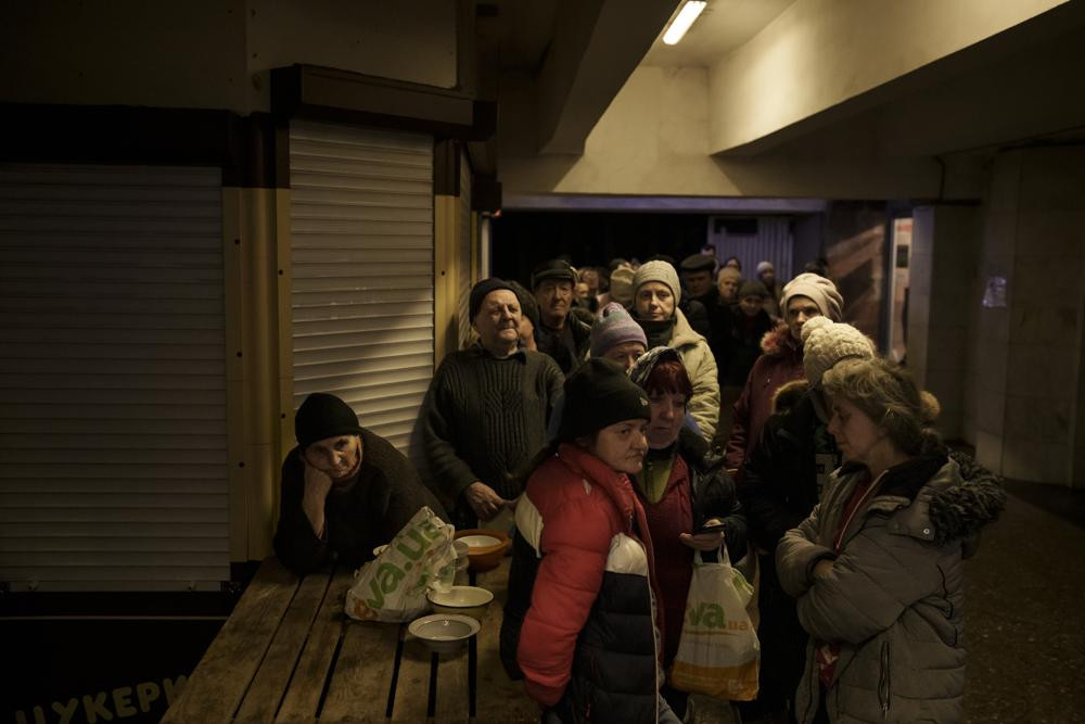 Mọi người xếp hàng mua thức ăn trong một ga tàu điện ngầm ở Kharkiv, Ukraine. Ảnh: AP.