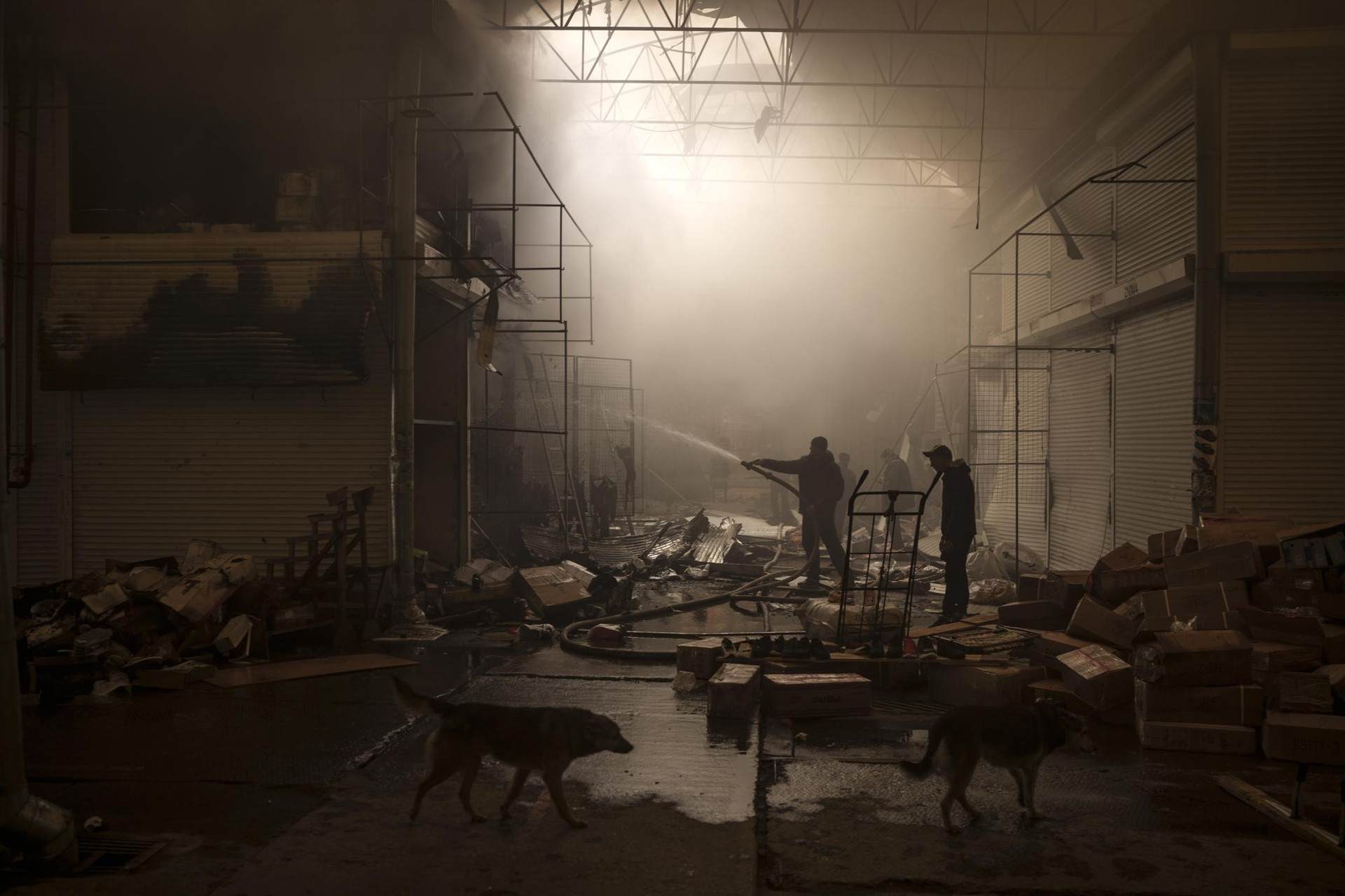 Mọi người cố gắng dập lửa trong một khu chợ ở Kharkiv, Ukraine. Ảnh: AP.