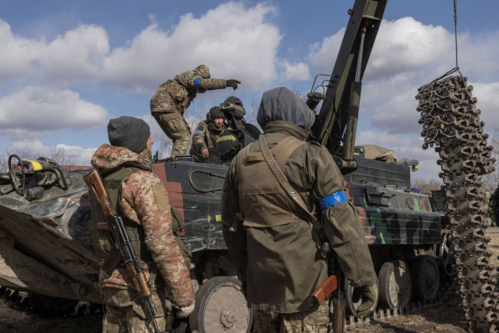 Các quân nhân Ukraine cố gắng sửa chữa phương tiện của họ ở làng Lukashi, ngoại ô thủ đô Kiev, Ukraine. Ảnh: Reuters.