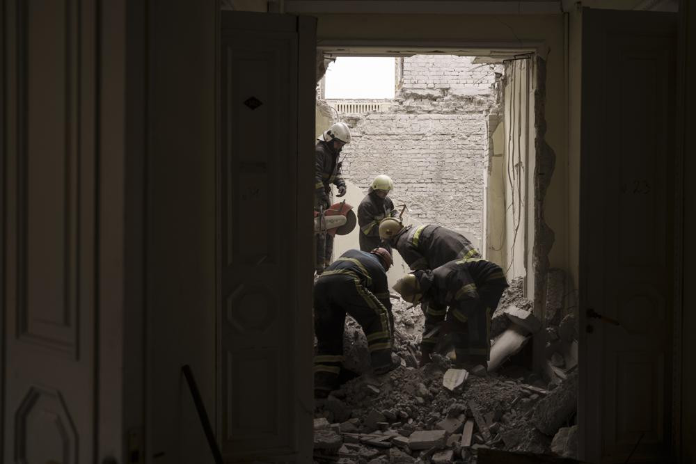 Các nhân viên cứu hộ tìm kiếm các thi thể dưới đống đổ nát của tòa nhà chính quyền khu vực bị hư hại nặng nề ở Kharkiv, Ukraine. Ảnh: AP.