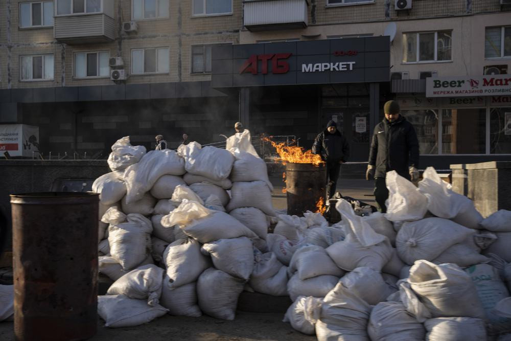 Các thành viên của lực lượng bảo vệ lãnh thổ sưởi ấm tại một điểm kiểm tra ở thủ đô Kiev, Ukraine. Ảnh: AP.