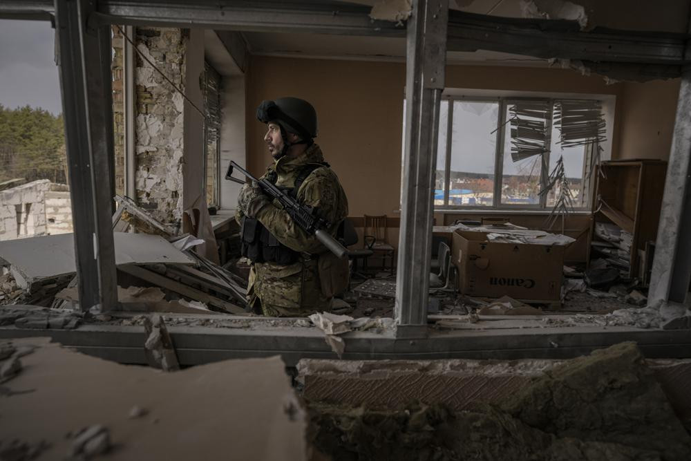 Một quân nhân Ukraine đứng trong một tòa nhà bị hư hại nặng nề ở Stoyanka, Ukraine. Ảnh: AP.