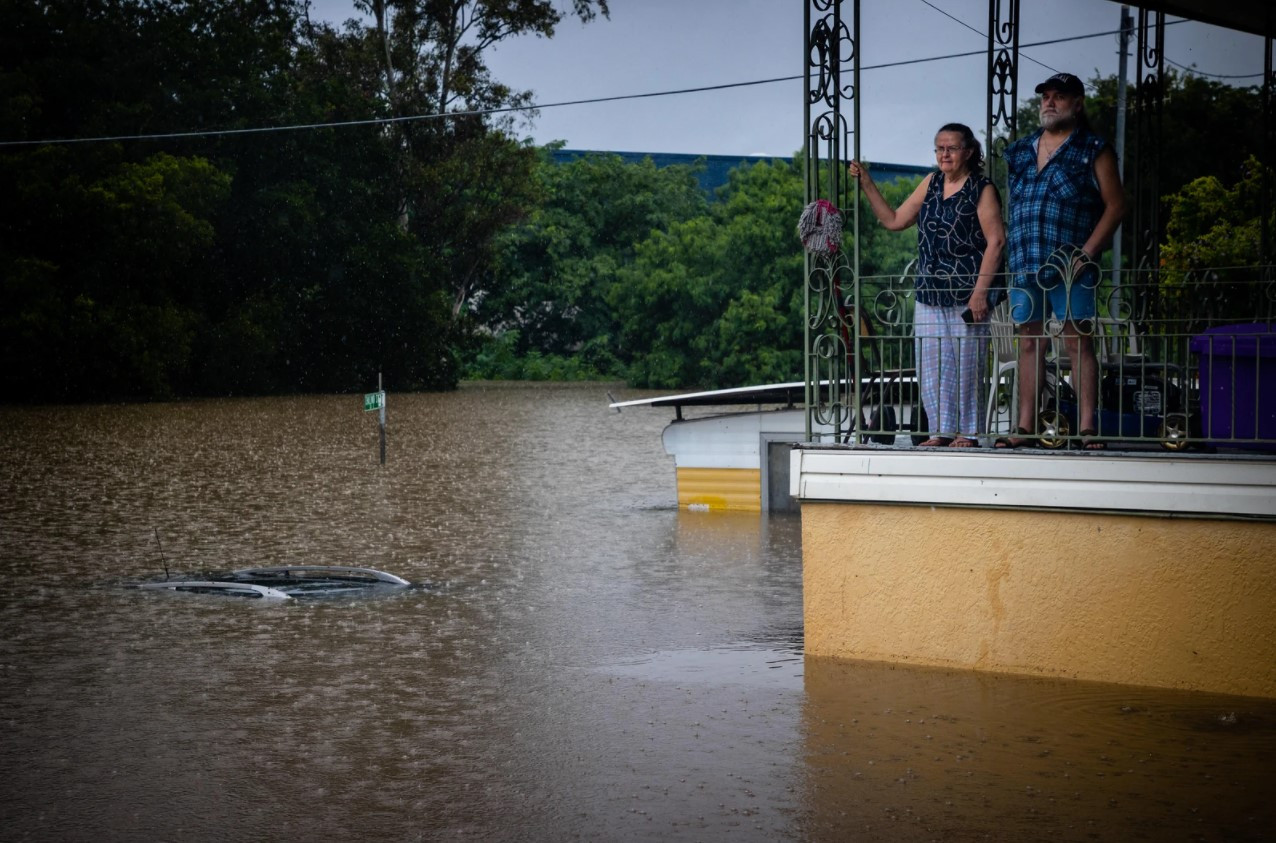 Người dân đứng nhìn dòng nước lũ từ ban công nhà ở phía tây Ipswich, bang Queensland, Australia. Ảnh: VICE.