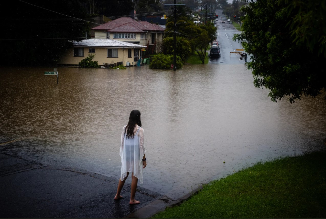 Một cô gái đứng nhìn dòng nước lũ ở phía tây Ipswich, bang Queensland, Australia. Ảnh: VICE.
