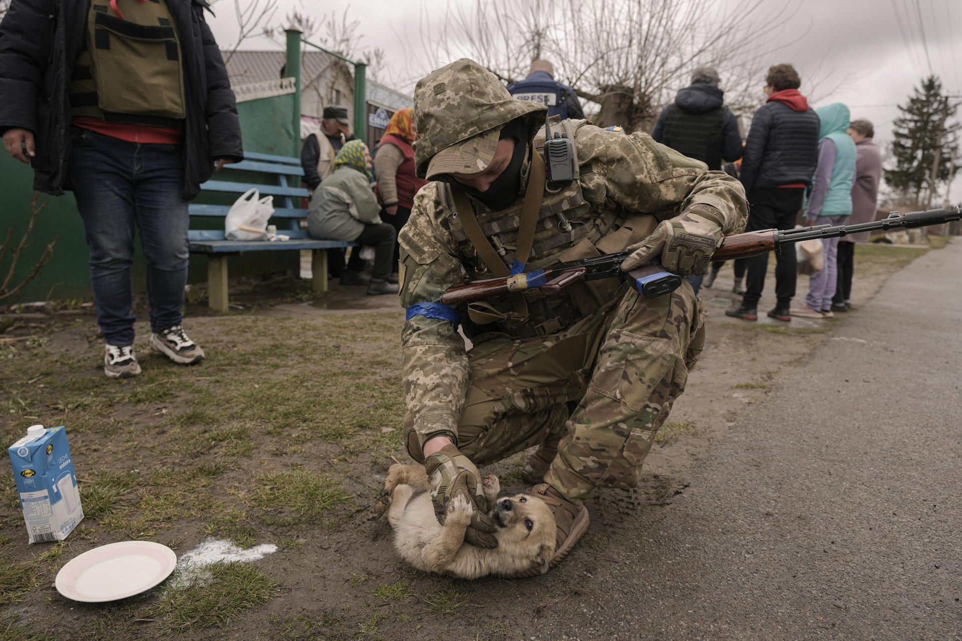Một quân nhân Ukraine cùng cư dân chờ phân phối thực phẩm ở làng Motyzhyn, Ukraine. Ảnh: AP.