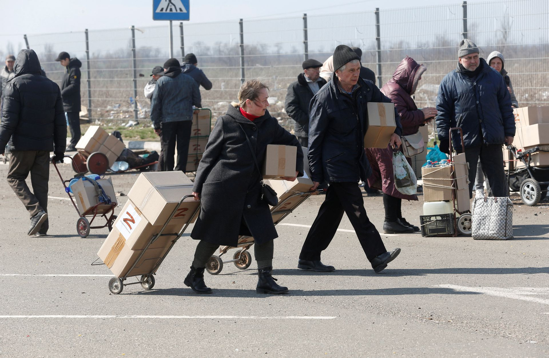 Người dân nhận các thùng hàng viện trợ nhân đạo ở thành phố cảng phía nam Mariupol, Ukraine. Ảnh: Reuters.