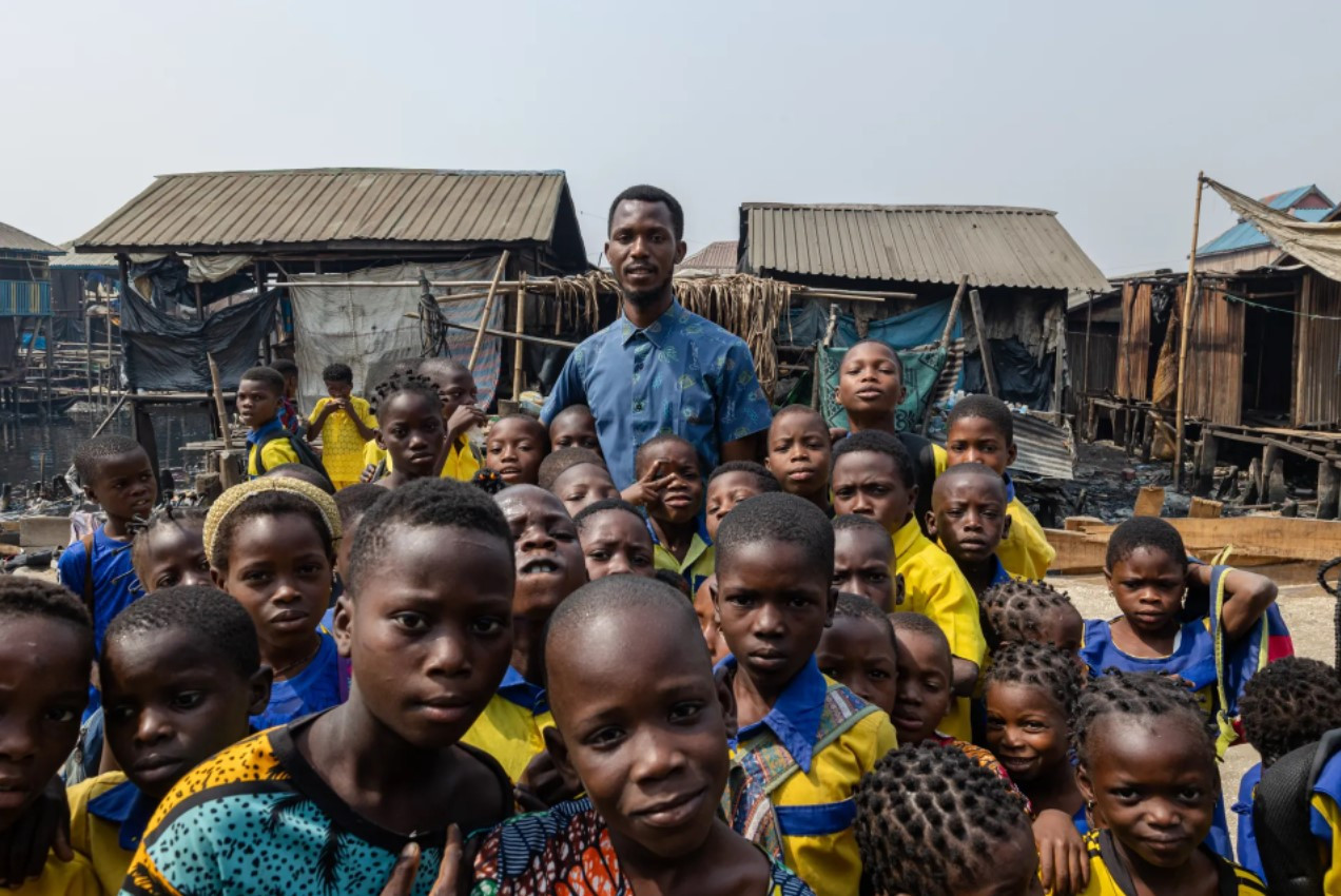 Thầy Emmanuel Abiodun Oke, 31 tuổi, hiệu trưởng trường Whanyinna, cùng các học sinh của mình. Ảnh: The Guardian.