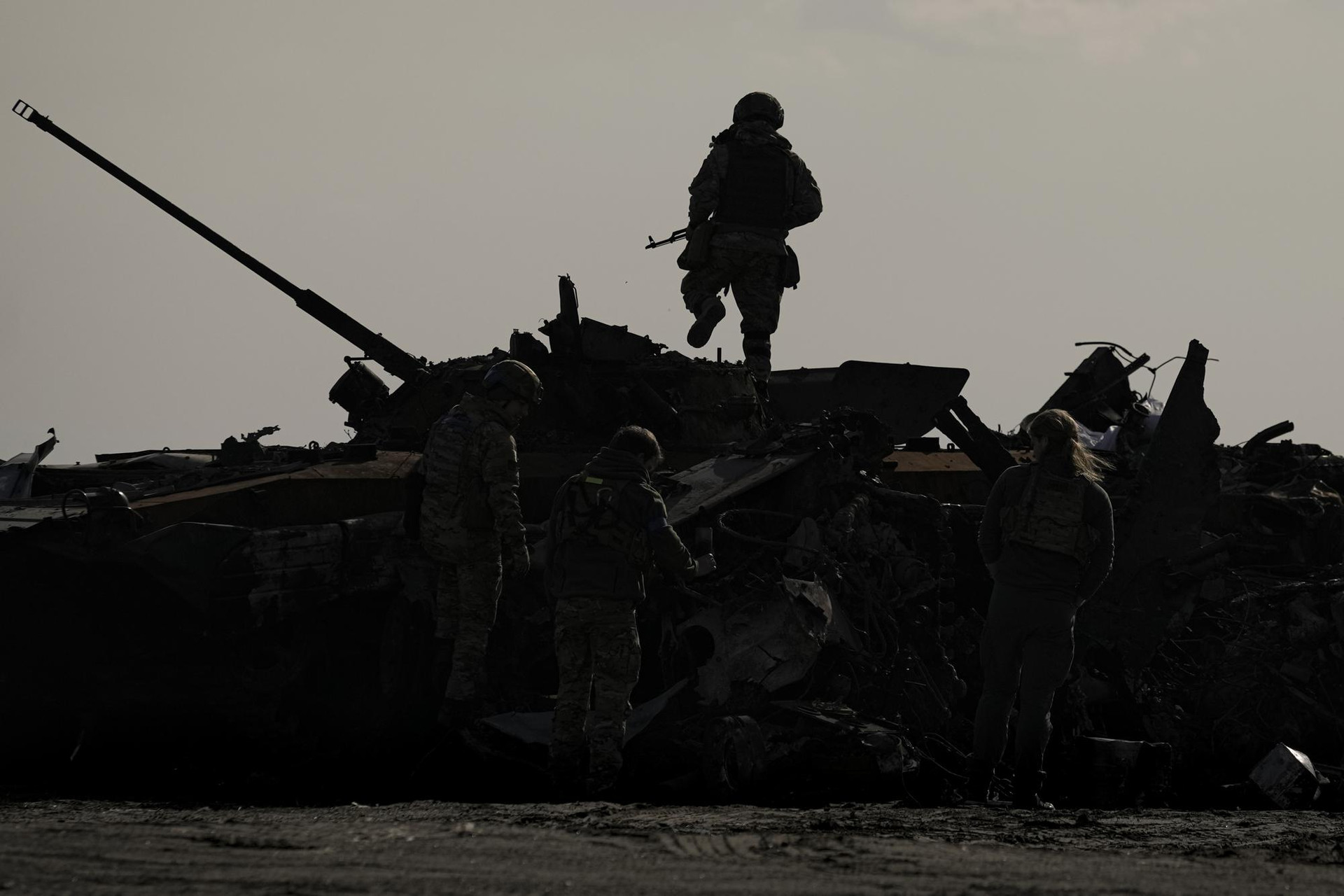 Quân nhân Ukraine đứng trên một chiếc xe tăng bị phá hủy ở Bucha, Ukraine. Ảnh: AP.