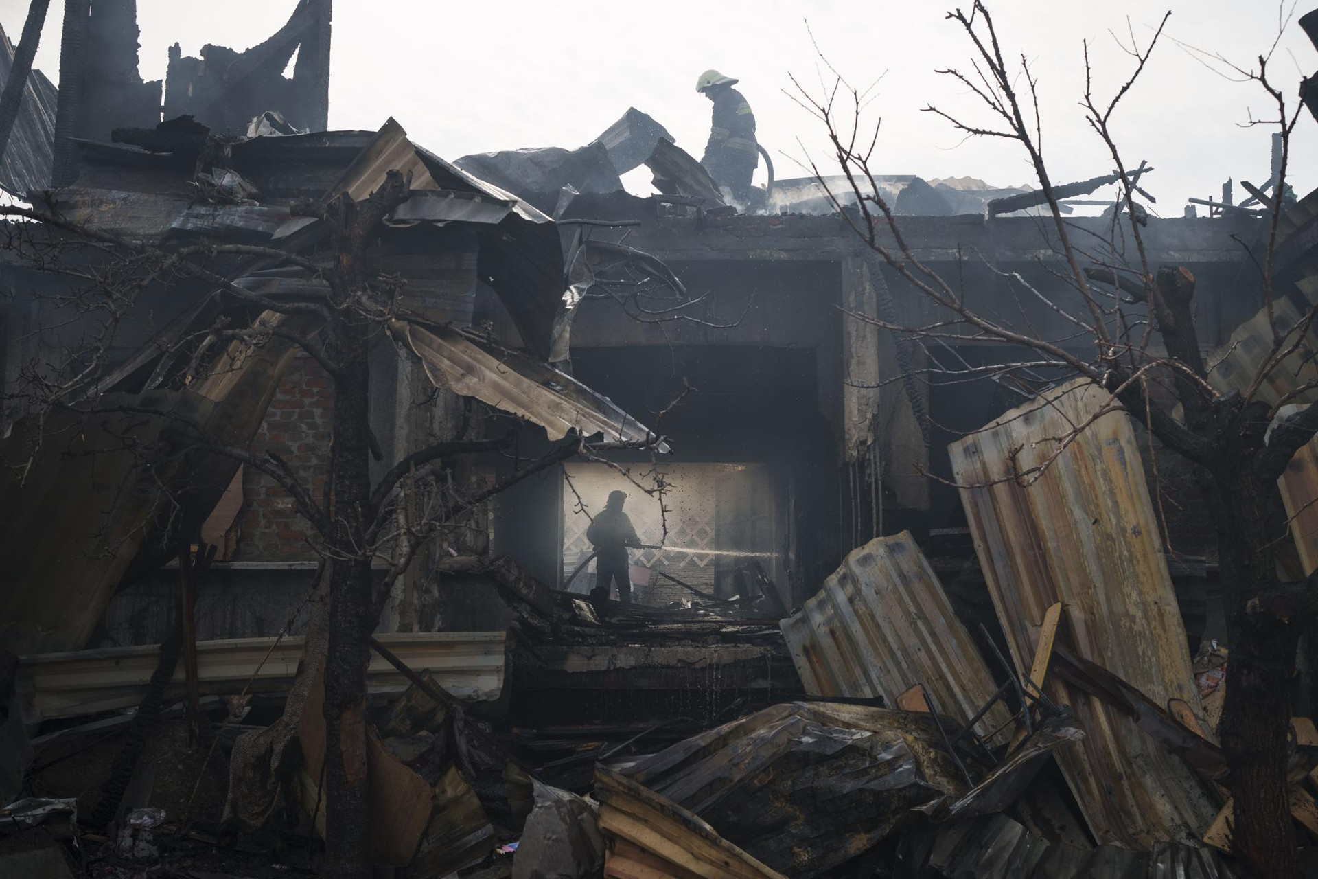 Lính cứu hỏa dập tắt đám cháy tại một ngôi nhà ở Kharkiv, Ukraine. Ảnh: AP.