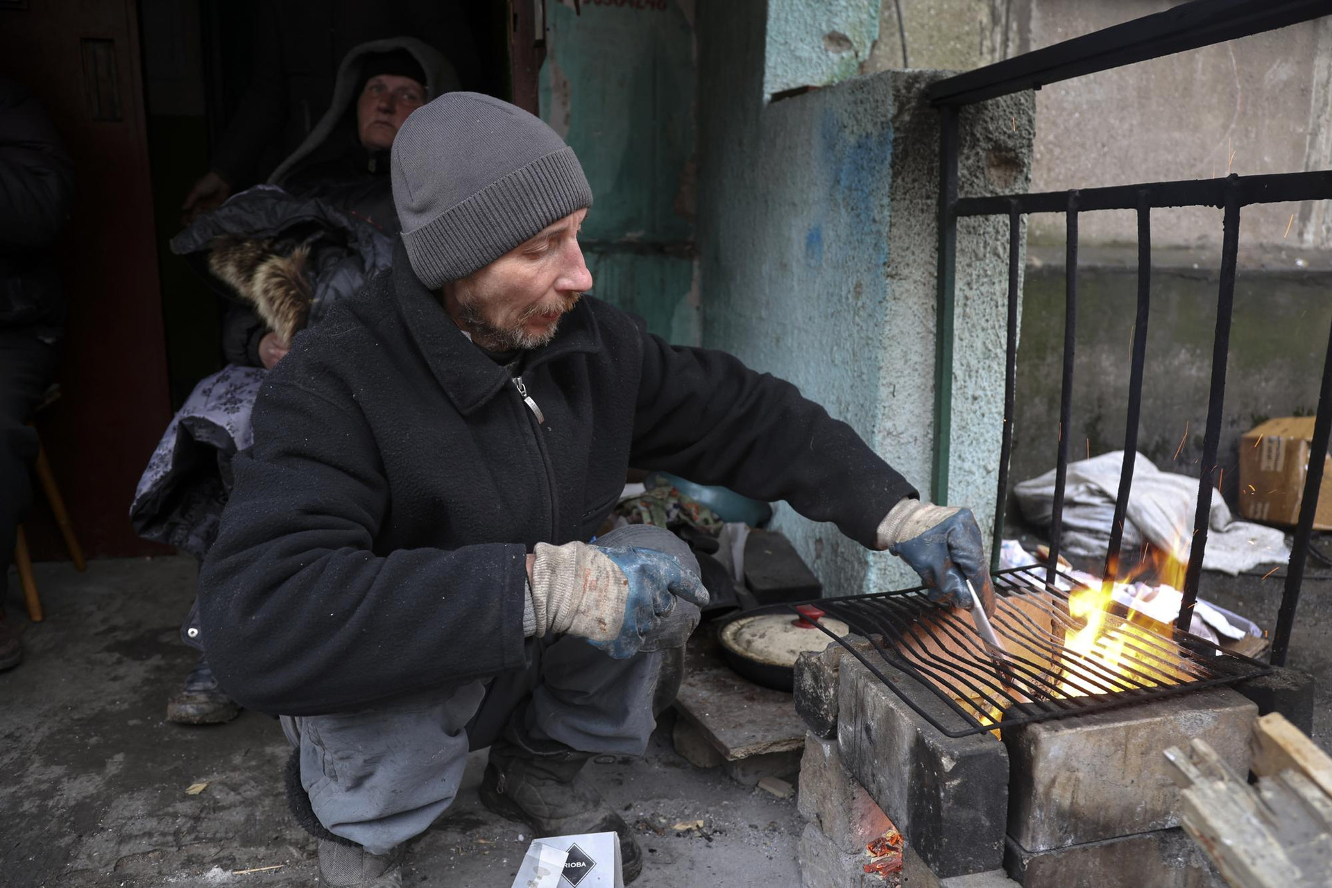 Người dân địa phương chuẩn bị nấu ăn ở thành phố Mariupol, Ukraine. Ảnh: AP.