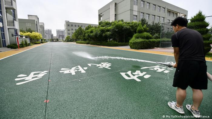 Một nhân viên kiểm tra khả năng thấm nước của bề mặt đường tại một trường tiểu học ở thành phố Càn An, tỉnh Hà Bắc, miền bắc Trung Quốc. Ảnh: DW.