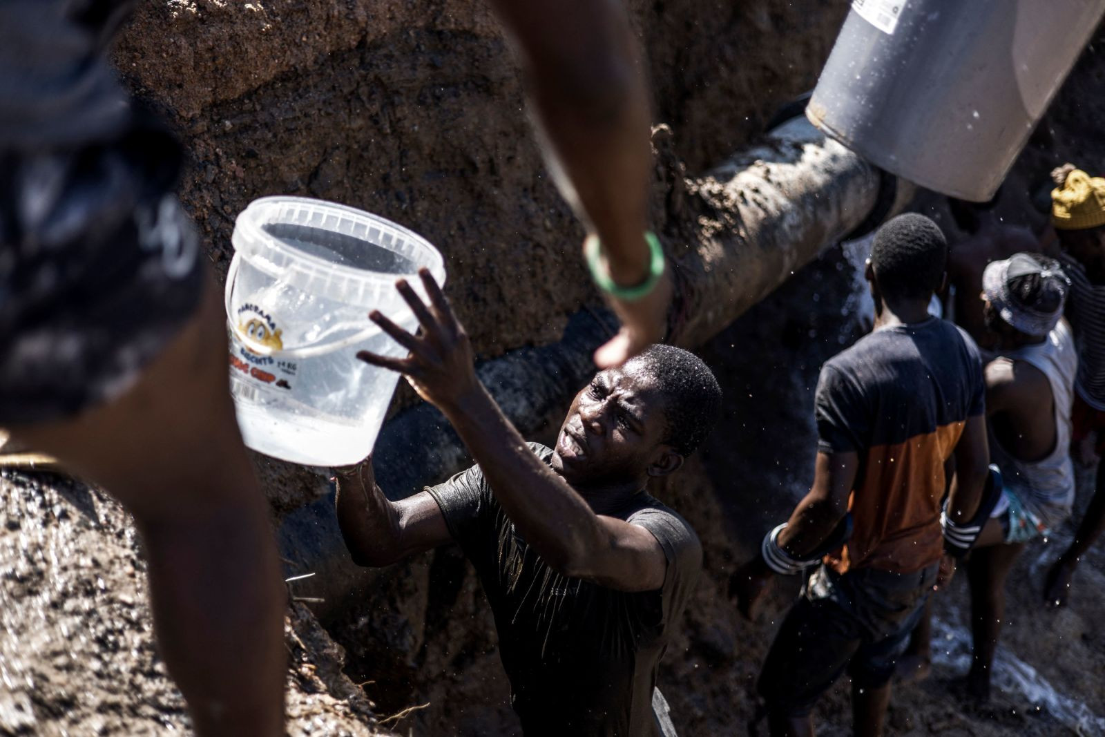Người dân lấy nước sạch từ một đường ống vỡ bên đường ở Amaoti. Ảnh: CNN.