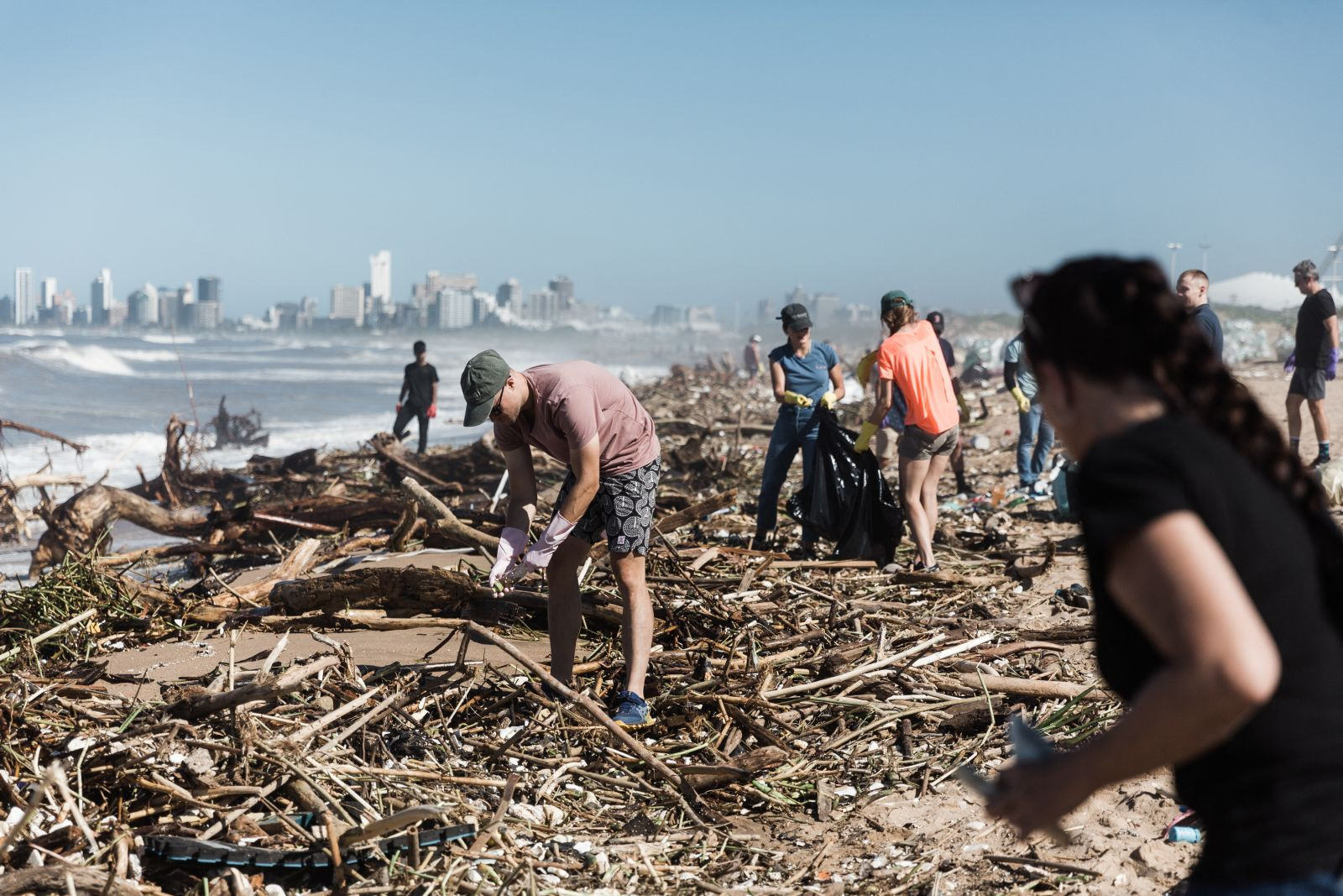 Các tình nguyện viên cùng làm việc để dọn dẹp các mảnh vỡ tại bãi biển Blue Lagoon ở Durban. Ảnh: CNN.