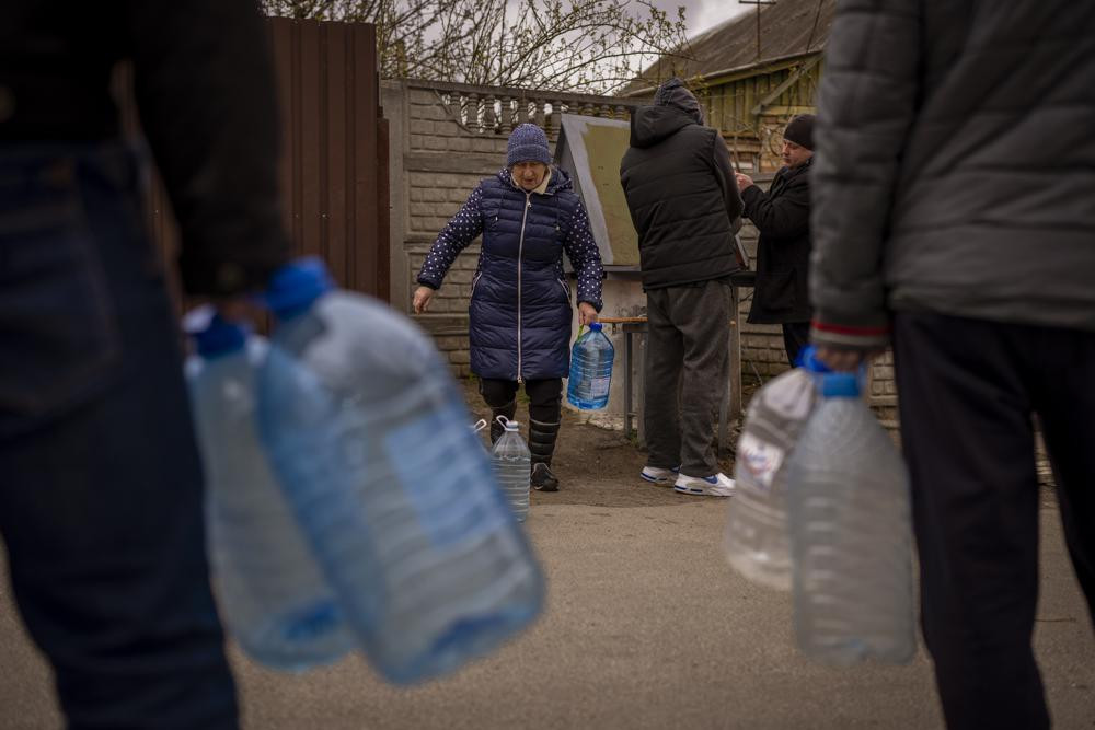 Cư dân địa phương lấy nước từ một đài phun nước công cộng ở Bucha, ngoại ô Kiev, Ukraine. Ảnh: AP.