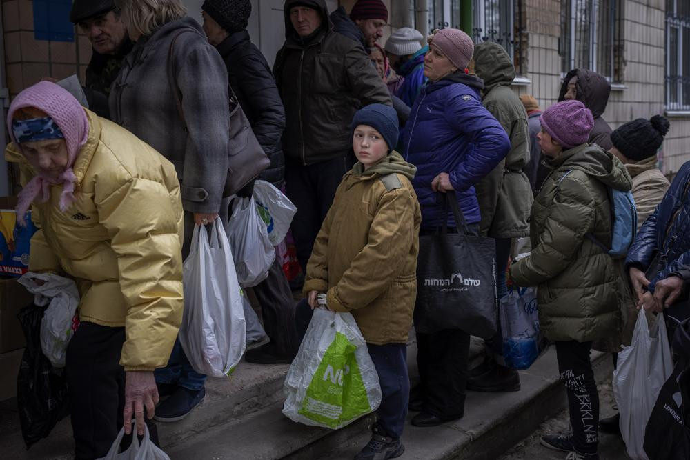Cư dân chờ đến lượt nhận thực phẩm quyên góp trong đợt phân phát viện trợ nhân đạo ở Bucha, ngoại ô Kiev, Ukraine. Ảnh: AP.