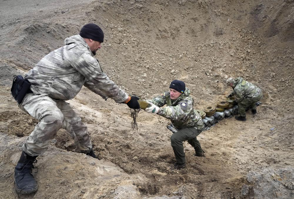 Các đặc công của Bộ Nội vụ Ukraine thu thập chất nổ gần một bãi mìn tại làng Moshchun gần Kiev, Ukraine. Ảnh: AP.