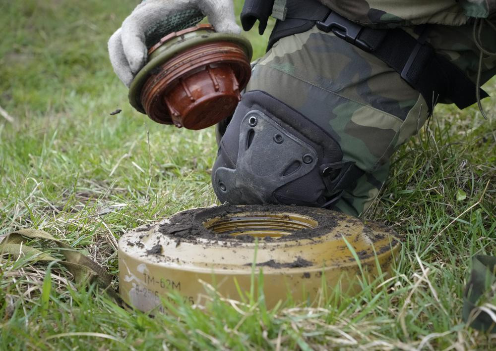 Một đặc công của Bộ Nội vụ Ukraine phá dỡ một quả mìn ở Irpin, gần Kiev, Ukraine. Ảnh: AP.