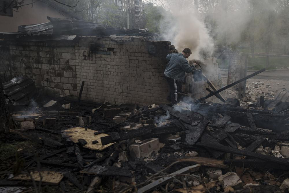 Người dân cố gắng dập tắt đám cháy tại một khu dân cư ở Kharkiv, Ukraine. Ảnh: AP.