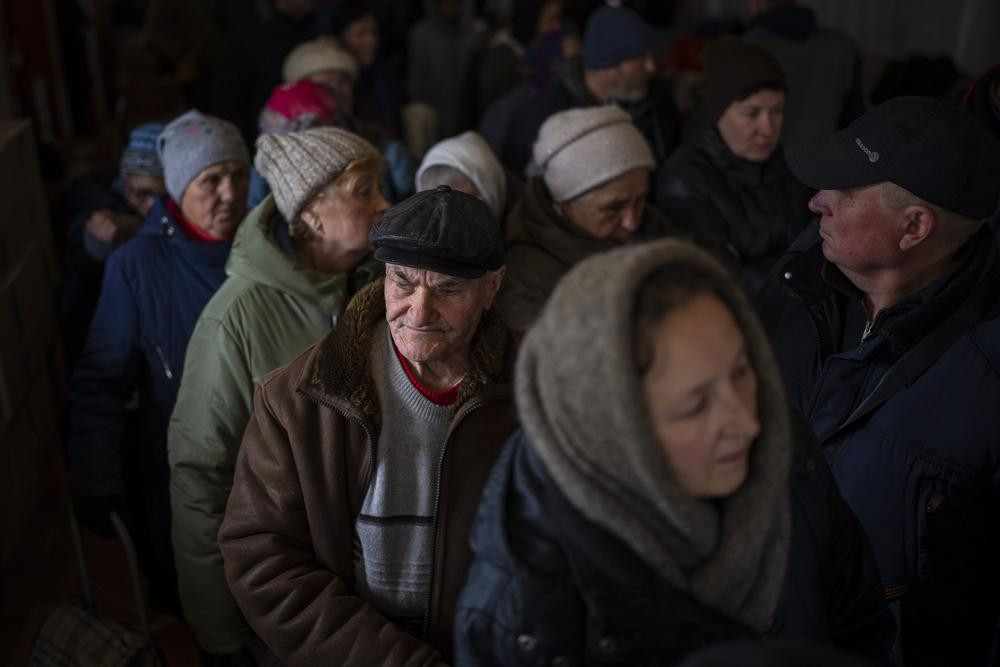 Người dân Ukraine xếp hàng nhận viện trợ nhân đạo ở Bucha, ngoại ô Kiev, Ukraine. Ảnh: AP.