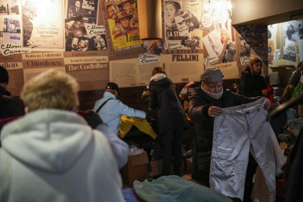 Người dân lựa quần áo tại một trung tâm phân phối viện trợ ở Lviv, miền tây Ukraine. Ảnh: AP.