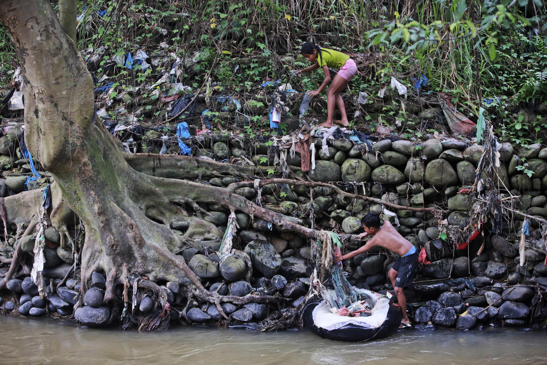 Hai đứa trẻ thu gom rác thải nhựa tại sông Babura bị ô nhiễm ở medan, Bắc Sumatra, Indonesia. Ảnh: AP.