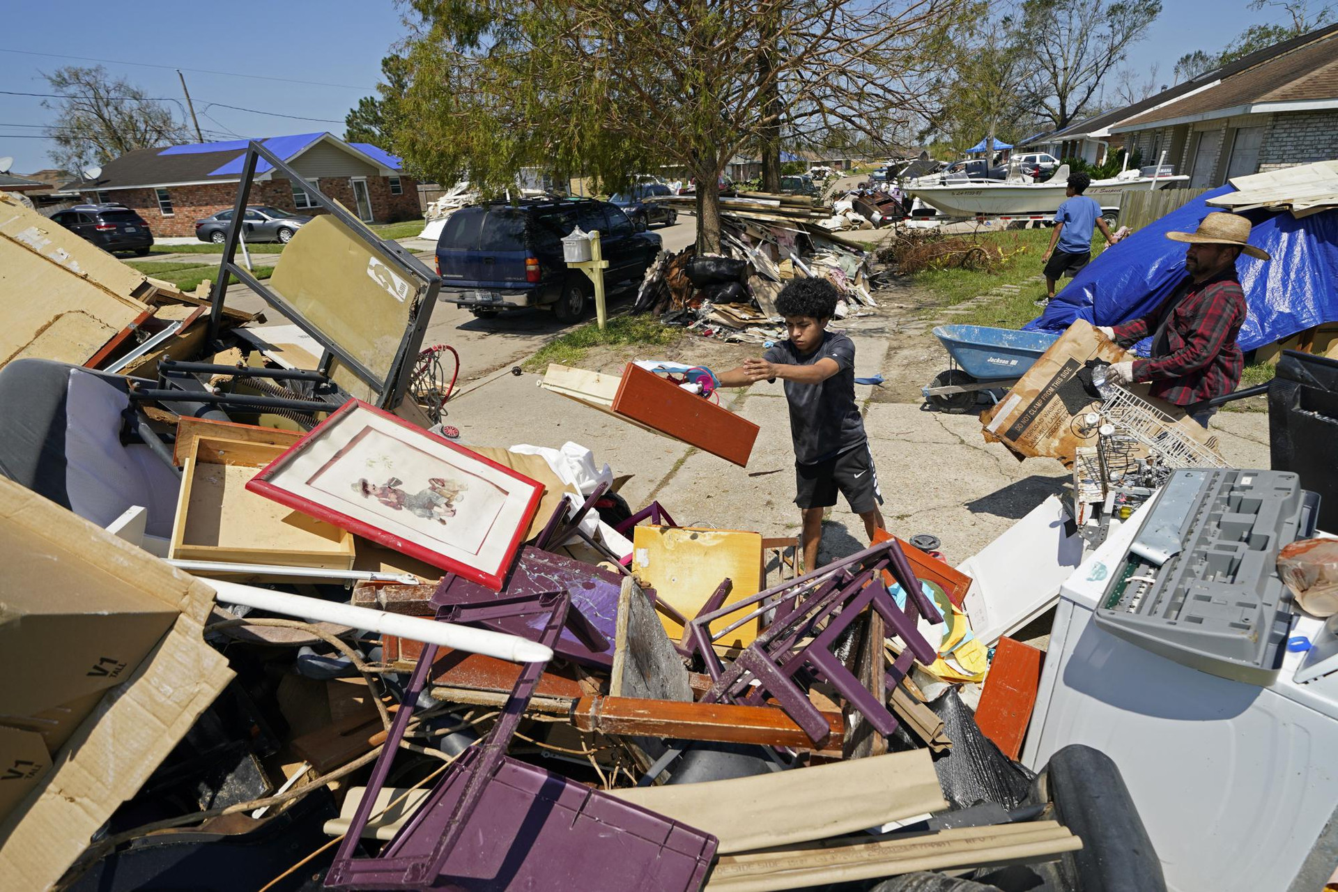 Người dân dọn dẹp rác thải sau cơn bão Ida ở LaPlace, La., Mỹ. Ảnh: AP.