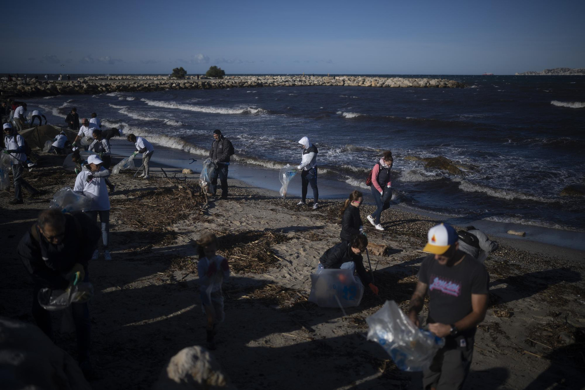 Các tình nguyện viên làm sạch một bãi biển khỏi rác thải bị cuốn trôi bởi một cơn bão ở Marseille, miền nam nước Pháp. Ảnh: AP.