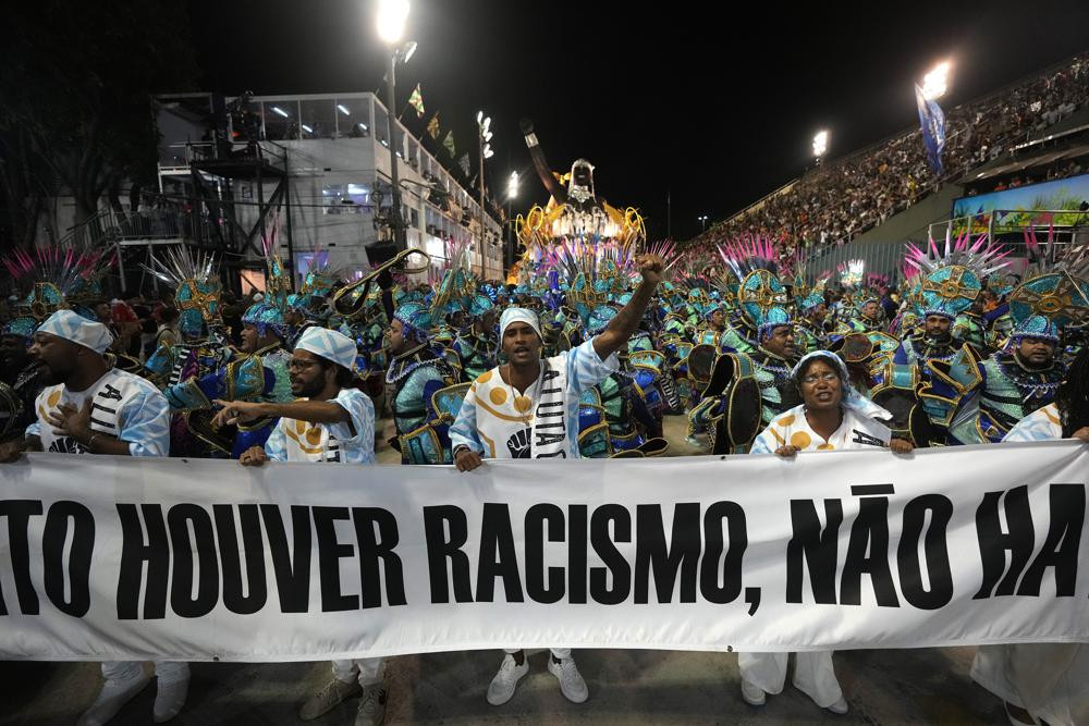 Những người biểu diễn cầm biểu ngữ chống phân biệt chủng tộc trong cuộc diễu hành tại Quảng trường Sambadrome ở Rio de Janeiro, Brazil. Ảnh: AP.