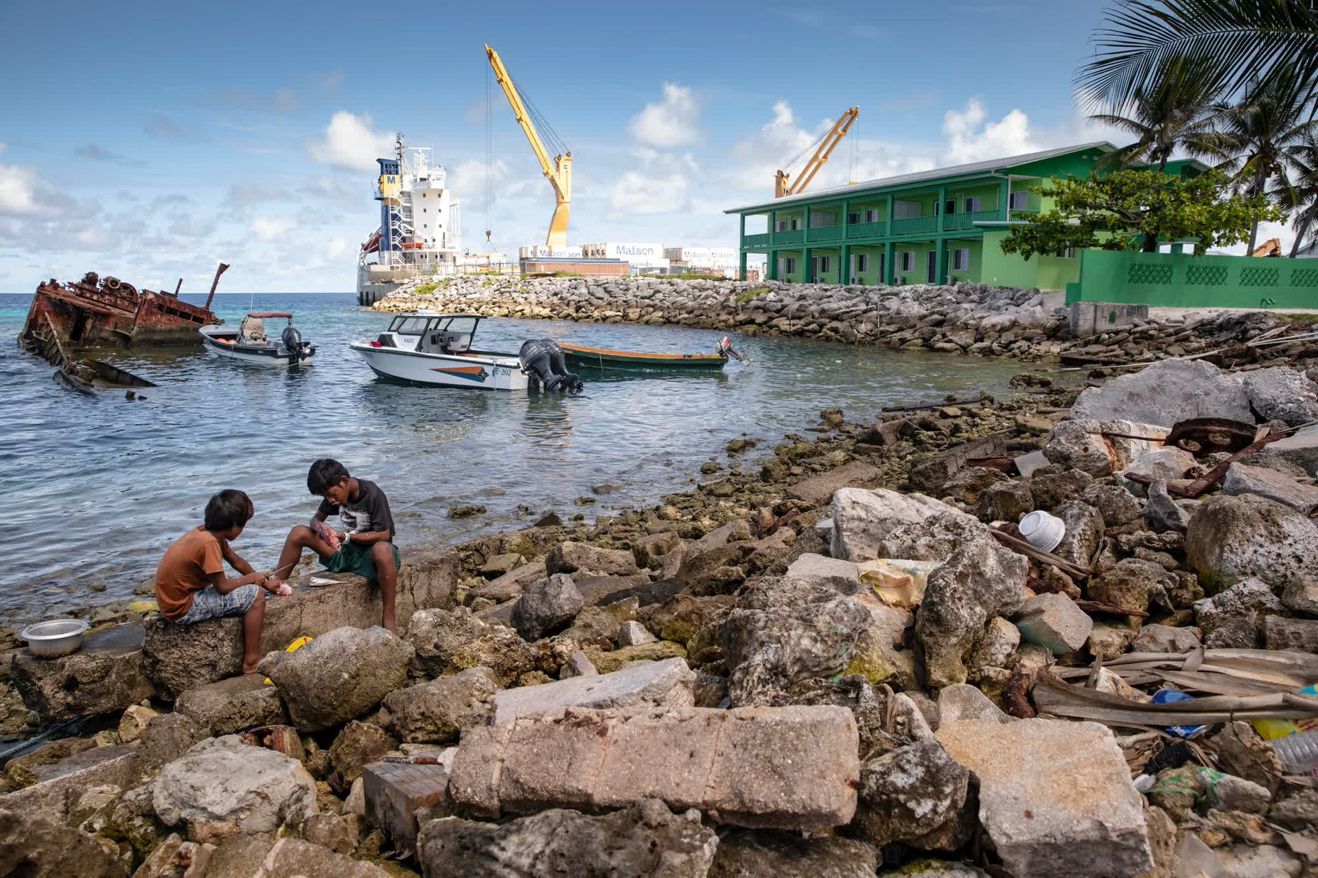 Những đứa trẻ thu gom cá dọc theo bờ biển của Đảo Ebeye thuộc Đảo san hô Kwajalein của Quần đảo Marshall. Ảnh: CNN.