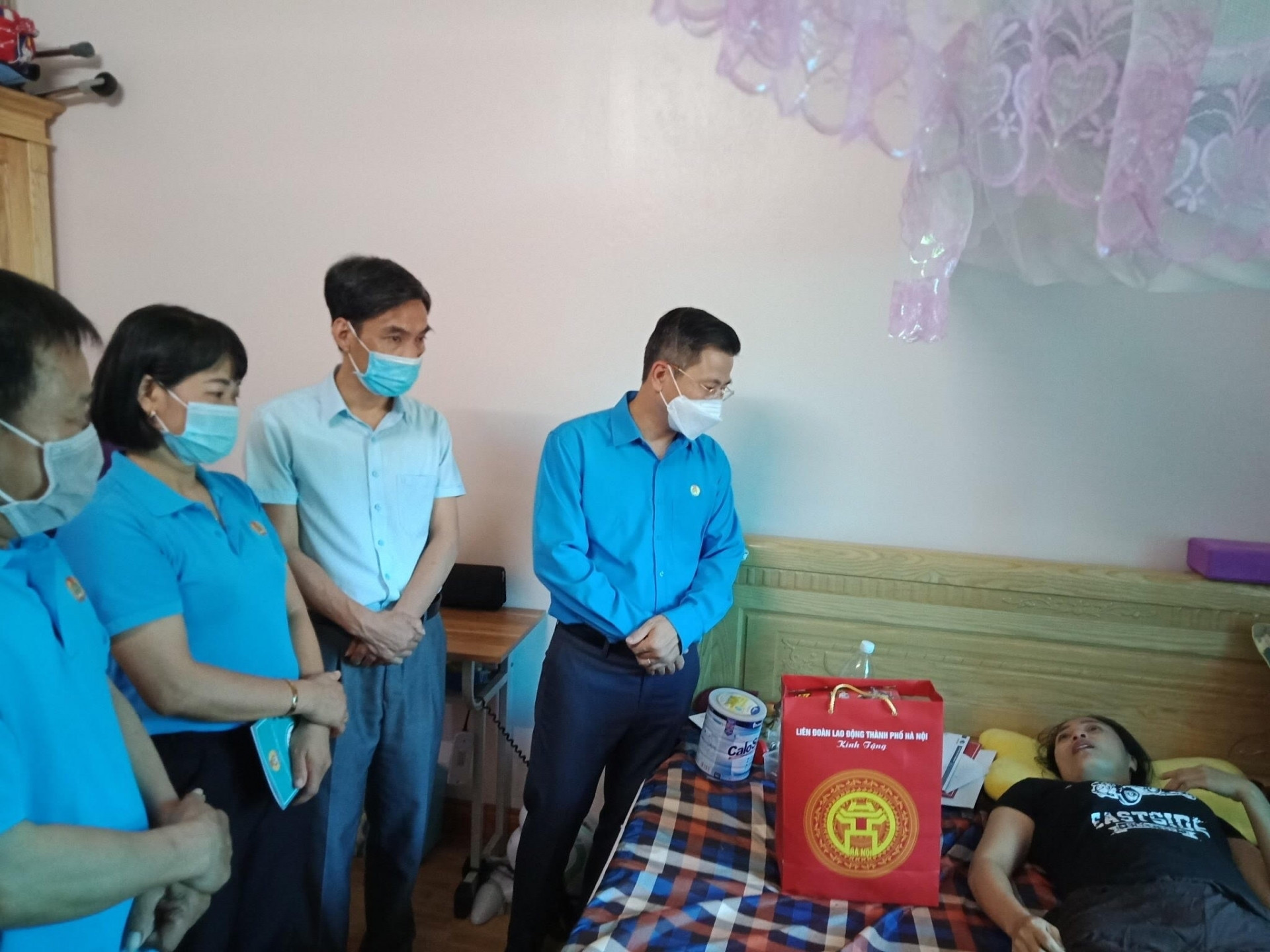 Ông Nguyễn Phi Thường, Chủ tịch LĐLĐ Thành phố Hà Nội (thứ 4, từ trái) chia sẻ với đoàn viên bị tai nạn lao động nhân dịp Tháng Công nhân và Tháng hành động về ATVSLĐ năm 2021.